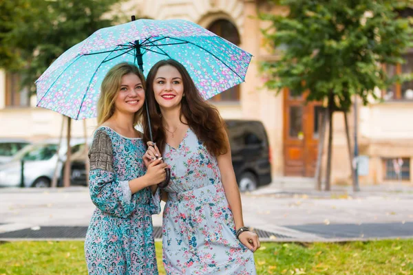 Portrét dvou šťastné ženy s deštníkem v ulici — Stock fotografie