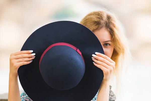 Retrato de la hermosa chica de moda jugando con el sombrero al aire libre — Foto de Stock