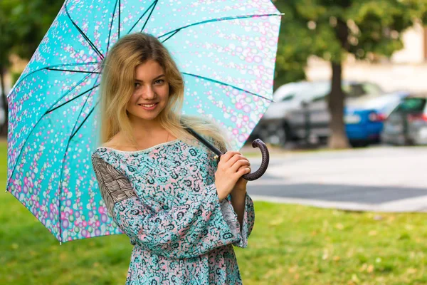 Ritratto di giovani donne felici con ombrello blu in strada — Foto Stock