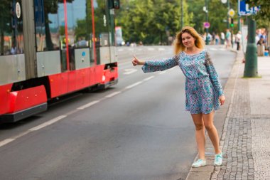 Genç kadının bir şehrin bir sokakta otostop yapması