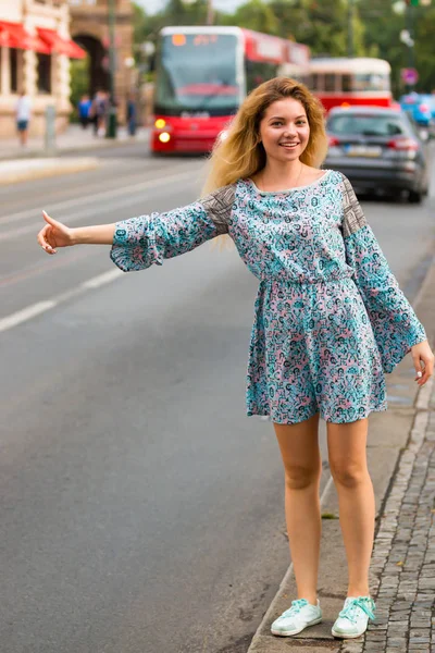 Νεαρή γυναίκα να κάνει το ωτοστόπ σε έναν δρόμο της πόλης — Φωτογραφία Αρχείου