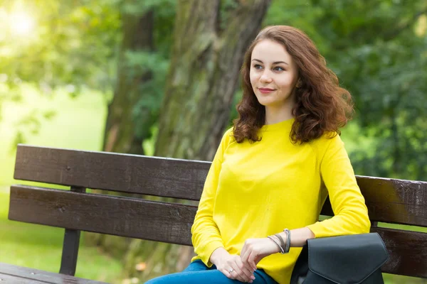 Portrait de la belle fille à la mode sur banc dans le parc — Photo