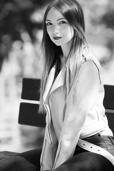 Retrato de menina na moda informal no banco no parque, cores pretas e brancas — Fotografia de Stock