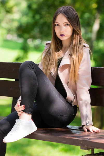 Retrato de chica informal de moda en el banco en el parque — Foto de Stock