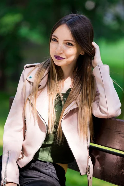 Retrato de chica informal de moda en el banco en el parque — Foto de Stock