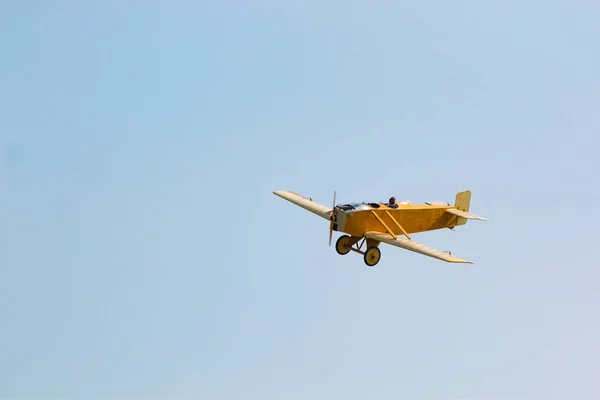 Винтажный желтый самолет в голубом небе — стоковое фото