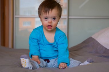 Down sendromlu şirin bir erkek bebeğin portresi.