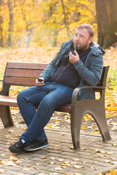 Jonge man rookt tabak pijp in park — Stockfoto