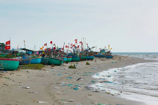 Coráculos de pesca tradicionales vietnamitas en la playa contaminada en un pueblo pesquero en Vietnam — Foto de Stock