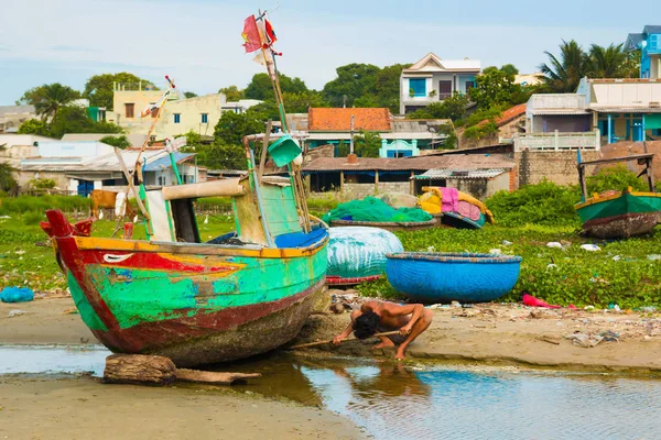MUI Ne, Vietnam - 02.11.2017: balıkçı köyü, MUI Ne, Vietnam kumsalda teknede temizlik balıkçı