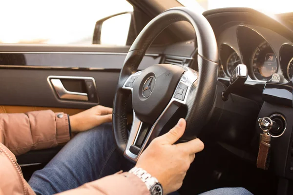 Prague, Çek Cumhuriyeti - 9.12.2017: sürücü Prag'da günbatımı zaman modern Mercedes Benz otomobil direksiyonuna