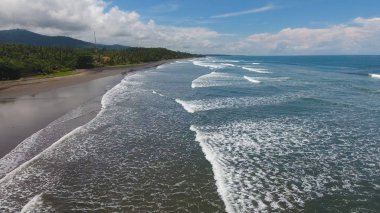 Bulutlar ile volkanik kum, mavi gökyüzü ile tropikal egzotik plaj. Kimse