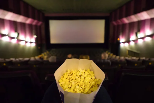 Cinema hall and pop corn in woman hands