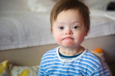 Down sendromlu şirin bir erkek bebeğin portresi.