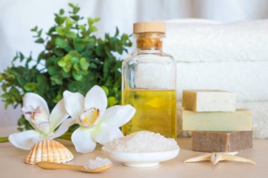 Sağlık ayarı. Deniz tuzu, sabun, havlu, petrol ve ahşap arka plan üzerinde çiçekler