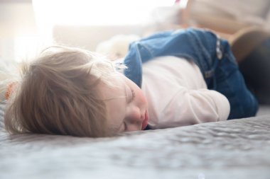 Down sendromlu yatakta uyuyan sevimli bebek