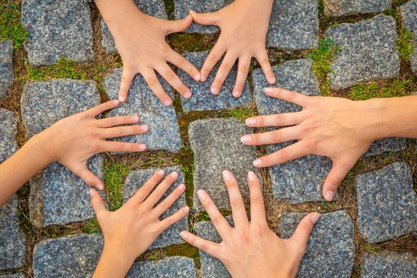 Różnorodność dorosłych i dzieci ręce w kółko nad nawierzchni tle kamienia — Zdjęcie stockowe