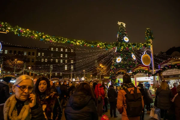 Praag, Tsjechië - 25.11.2019: Kerst kermis en versierde kerstboom op Namesti Miru plein tegen de bouw van de St. Ludmila kerk, Praag, Tsjechië — Stockfoto