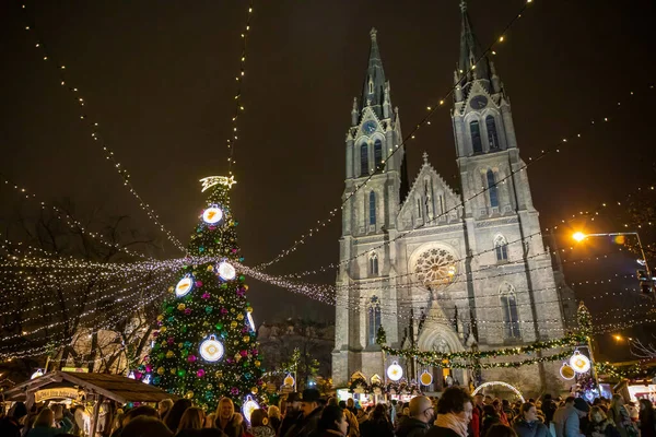 Praag, Tsjechië - 25.11.2019: Kerst kermis en versierde kerstboom op Namesti Miru plein tegen de bouw van de St. Ludmila kerk, Praag, Tsjechië — Stockfoto