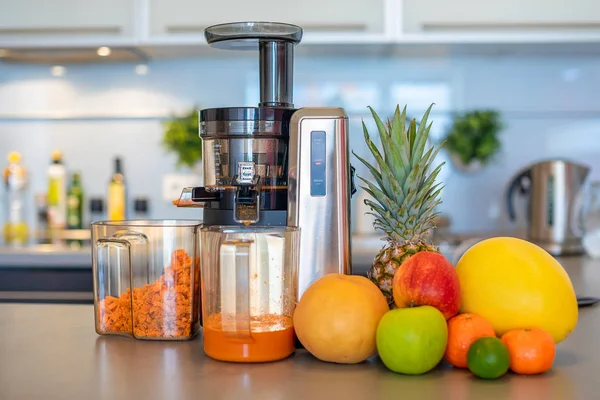 과일 주스를 집 부엌에서 주스 기계로 만드는 것, 건강 한 식사 생활 방식의 개념 — 스톡 사진