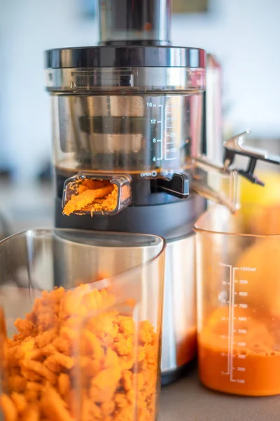 El primer plano de la pulpa de zanahoria de la preparación del proceso del jugo fresco en el exprimidor —  Fotos de Stock