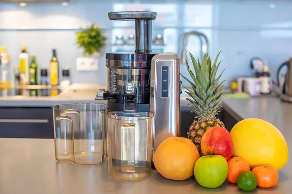 Making fruit juice with juicer machine in home kitchen, healthy eating lifestyle concept — Stock Photo, Image