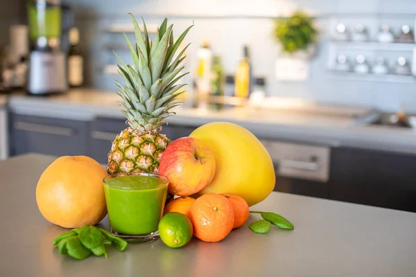 Mutfak arka planında farklı tropikal meyveler ve smoothie, sağlıklı beslenme tarzı konsepti. — Stok fotoğraf