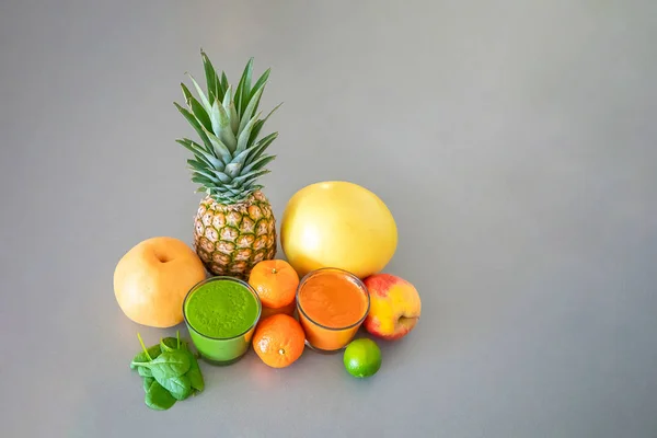Різні тропічні фрукти і смузі на сірому фоні, здорове харчування концепції способу життя — стокове фото