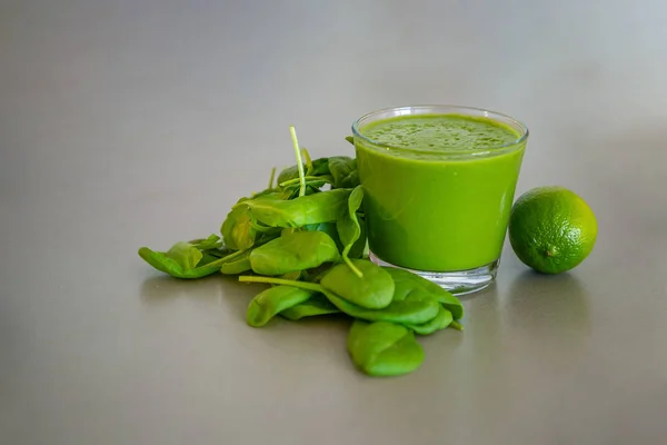 Зелений шпинат смузі зі свіжим шпинатом на сірому фоні, здорове харчування концепції способу життя — стокове фото