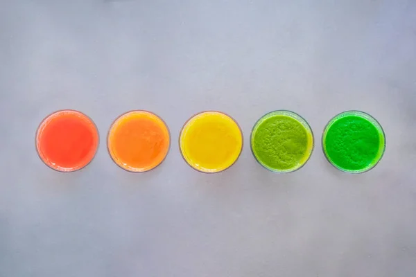 Top view of selection of five colorful smoothies on grey background with copy space, , healthy eating lifestyle concept