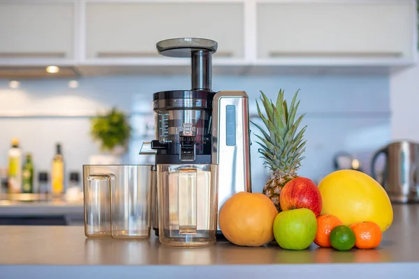 Haciendo jugo de fruta con la máquina del juicer en la cocina casera, concepto sano del estilo de vida de la alimentación —  Fotos de Stock