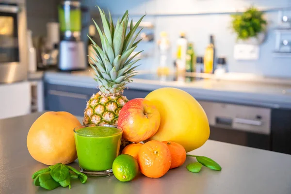 Mutfak arka planında farklı tropikal meyveler ve smoothie, sağlıklı beslenme tarzı konsepti. — Stok fotoğraf