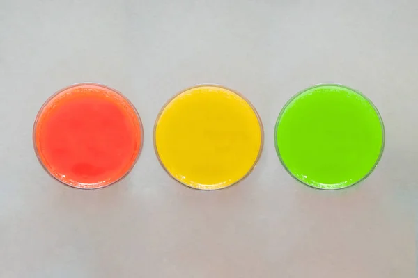 Top view of selection of three colorful smoothies on grey background with copy space, , healthy eating lifestyle concept