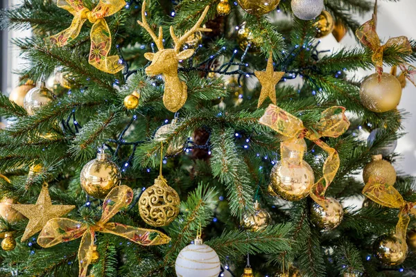 Κοντινό πλάνο του χριστουγεννιάτικου δέντρου με μπιχλιμπίδια και χρυσά παιχνίδια, φόντο Χριστουγέννων — Φωτογραφία Αρχείου