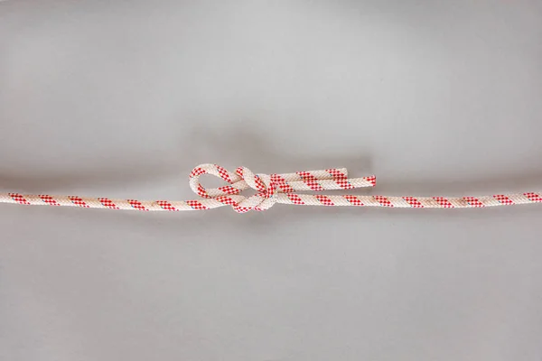 Singly slipped reef ship knot on grey background