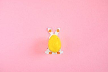 Paskalya yumurtası ve kağıt siluetleri pembe arka planda bir Paskalya tavşanının