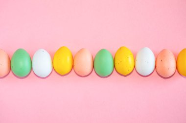 Pembe arka planda renkli paskalya yumurtaları