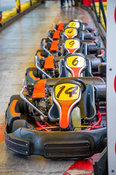 Row of carts with approval yellow numbers, ready to start inside a open track circuit — Stock Photo, Image