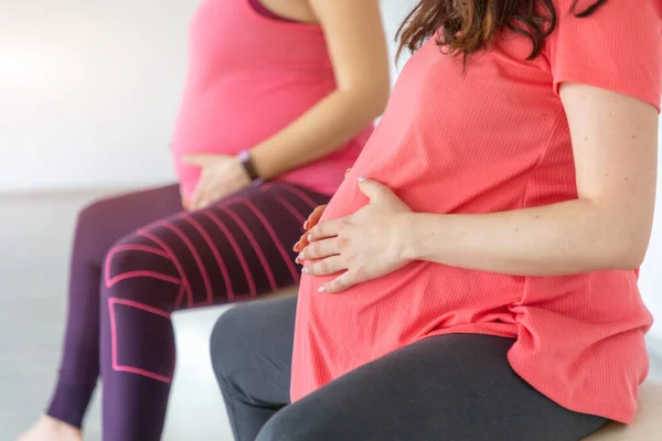 Terhes nők jógáznak és őrjöngenek jóga órán, egészséges terheskori életmód — Stock Fotó