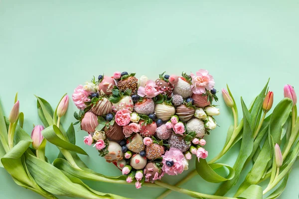 Hartvormige doos met handgemaakte chocolade bedekte aardbeien met verschillende toppings en bloemen als geschenk op Valentijnsdag op roze achtergrond met vrije ruimte voor tekst — Stockfoto