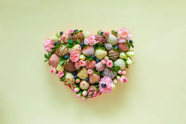 Herzförmige Schachtel mit handgemachter Erdbeere in Schokolade und Blumen als Geschenk zum Valentinstag auf gelbem Hintergrund — Stockfoto