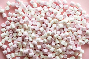 Pembe arka planda pembe ve beyaz mini marşmelovların arka planı veya dokusu, tatlı yiyecekler