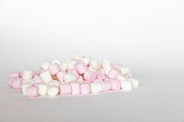 Mini guimauves roses et blanches sur fond blanc, nourriture sucrée — Photo