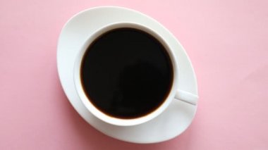Küçük bir fincan kahve pembe bir arka plan üzerinde
