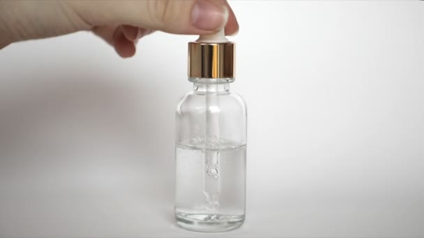 Botella de vidrio gotero Mock-Up wth ácido hialurónico sobre fondo blanco, suero de belleza — Vídeo de stock