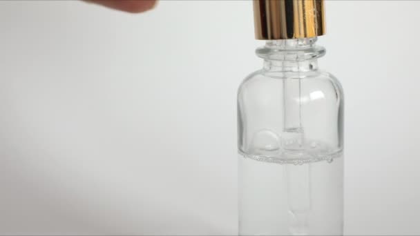 Капельница бутылка макет-ап с гиалуроновой кислотой на белом фоне, сыворотка красоты — стоковое видео