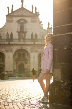 Genç sarışın kadın güneşli bir günde Prag 'daki Charles Köprüsü' nde yürüyor.