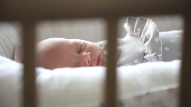 Nahaufnahme Porträt eines schönen Neugeborenen, das im Bett schläft — Stockvideo