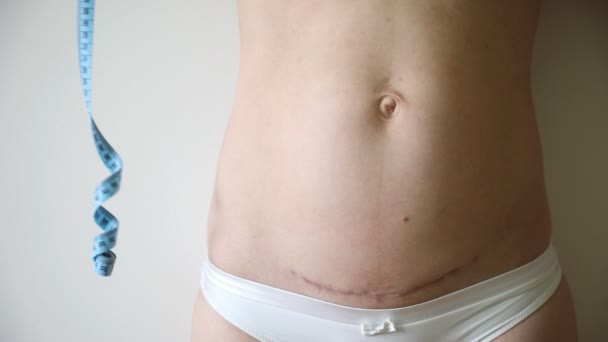 Mujer con cesárea después del parto y cinta métrica — Vídeos de Stock