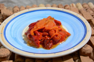 Kızarmış biber, soyulmuş, dilimlenmiş ve yağ, sarımsak ve tuzla tatlandırılmış.